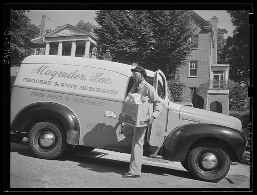 Washington, D.C. A Magruder, Inc. delivery truck on which is displayed a United States Truck Conservation Corps pledge in front of a fashionable home, showing the driver alighting with a box of groceries