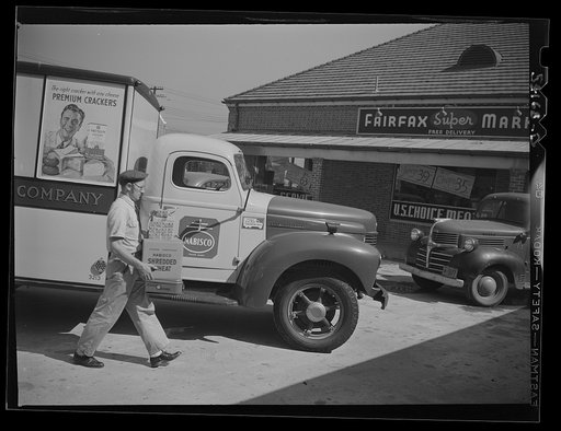 Fairfax, Virginia. A Nabisco truck on the door of which is displayed a United States Truck Conservation Corps pledge. The driver is taking a box of packaged goods into the Fairfax supermarket