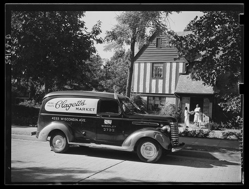 Washington, D.C. A Clagett Market delivery truck displaying a United States Truck Conservation Corps pledge standing in front of a residence where the driver is handing a basket of groceries to a colored maid