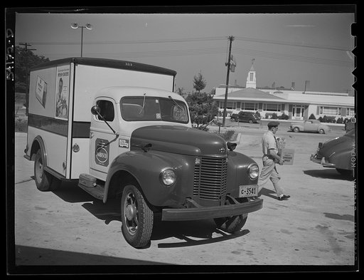 Fairfax, Virginia. A Nabisco truck stopping at a market where the driver is making a delivery. On the front of the truck is displayed a United States Truck Conservation Corps pledge