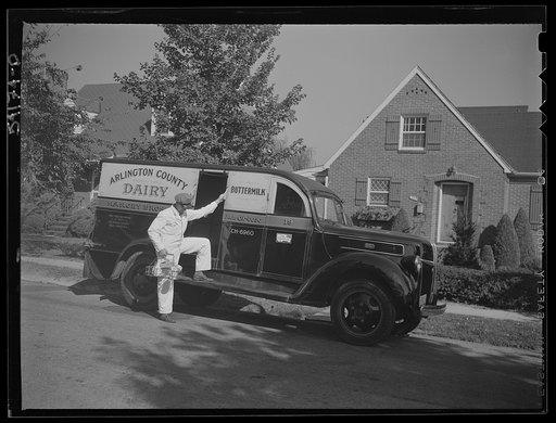 Arlington (?), Virginia. Arlington County dairy truck from which a driver is alighting with a tray of milk bottles. On the door of the truck is displayed a United States Truck Conservation Corps pledge