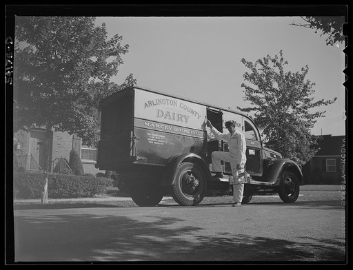 Arlington (?), Virginia. Arlington County dairy truck from which a driver is alighting with a tray of milk bottles. On the door of the truck is displayed a United States Truck Conservation Corps pledge