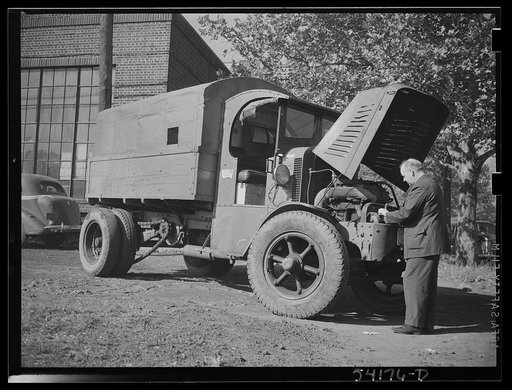 Washington, D.C. A man looking at the motor of a commercial truck on the side of which is displayed a United States Truck Conservation Corps pledge