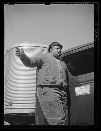 Washington, D.C. A colored driver on the running board of an autocar van giving some directions to someone ahead. A pledge to the United States Truck Conservation Corps is displayed on the door of the car