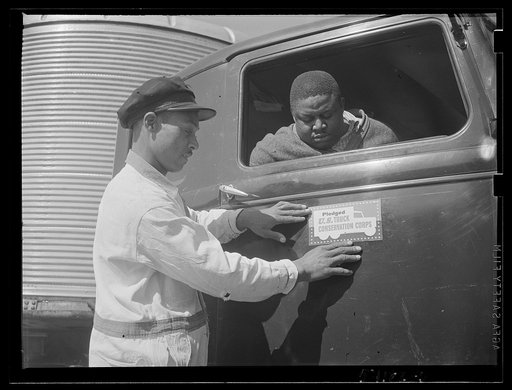 Washington, D.C. A colored driver and an attendant of a long distance hauling van looking at the United States Truck Conservation Corps pledge on the door of the car