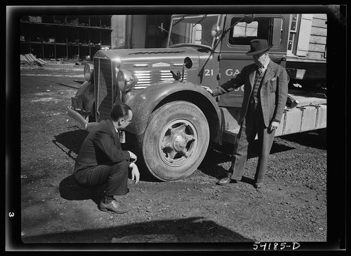 Washington, D.C. A Galliher and Huguely, Inc. truck, showing two men looking at one of the tires