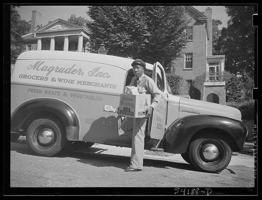 Untitled photo, possibly related to: Washington, D.C. A Magruder, Inc. delivery truck on which is displayed a United States Truck Conservation Corps pledge in front of a fashionable home, showing the driver alighting with a box of groceries
