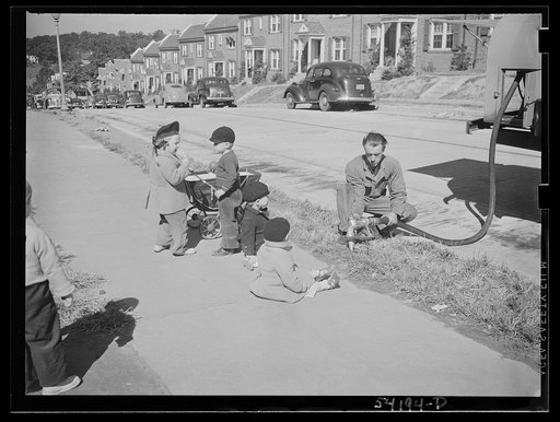 Untitled photo, possibly related to: Washington, D.C. A fuel-oil truck driver filling a tank at a residence. Three small boys fascinated with the operation are sprawled on the sidewalk beside him