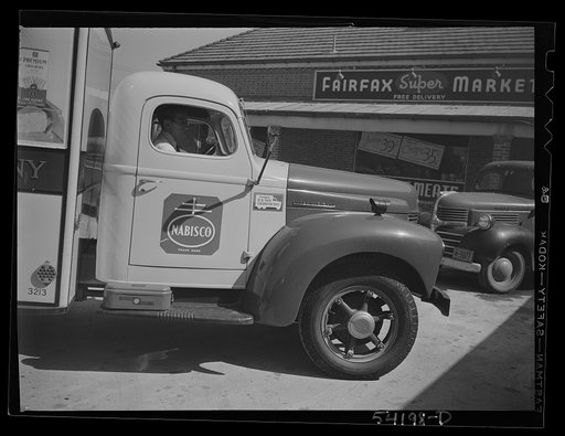 Untitled photo, possibly related to: Fairfax, Virginia. A Nabisco truck stopping at a market where the driver is making a delivery. On the front of the truck is displayed a United States Truck Conservation Corps pledge