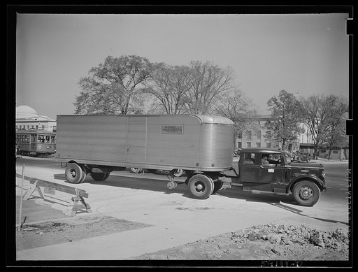 Untitled photo, possibly related to: Washington, D.C. An autocar long distance hauling van, showing a United States Truck Conservation Corps pledge on the door. The driver, standing on the running board, is apparently directing someone in front of it