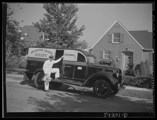 Untitled photo, possibly related to: Arlington (?), Virginia. Arlington County dairy truck from which a driver is alighting with a tray of milk bottles. On the door of the truck is displayed a United States Truck Conservation Corps pledge