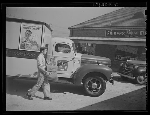 Untitled photo, possibly related to: Fairfax, Virginia. A Nabisco truck stopping at a market where the driver is making a delivery. On the front of the truck is displayed a United States Truck Conservation Corps pledge