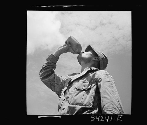 Fort Belvoir, Virginia. A soldier drinking from a G.I. water canteen