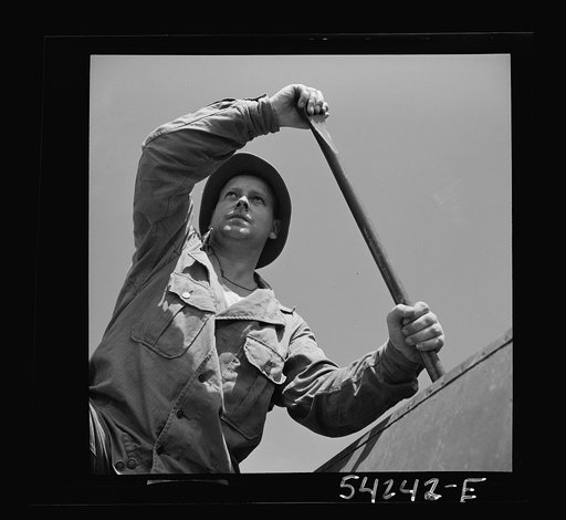 Fort Belvoir, Virginia. A soldier of the United States Army engineer corps paddling a barge