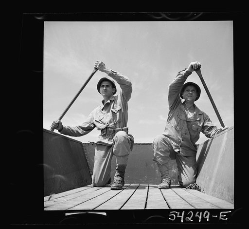 Fort Belvoir, Virginia. Two soldiers of the United States Army Engineer Corps paddling a barge
