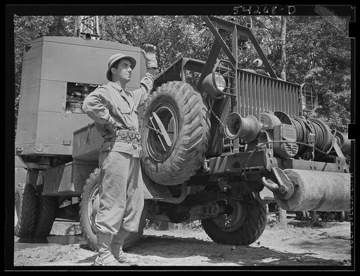 Fort Belvoir, Virginia. A soldier standing beside a truck with a mounted crane on it