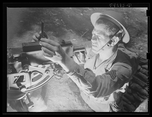 Untitled photo, possibly related to: Fort Belvoir, Virginia. A sergeant in the United States Army Engineer Corps adjusting the sight of a machine gun