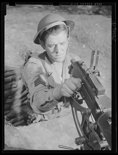 Untitled photo, possibly related to: Fort Belvoir, Virginia. A sergeant in the United States Army Engineer Corps adjusting the sight of a machine gun