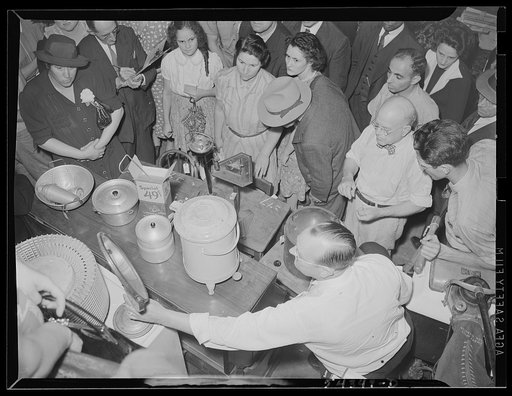 Washington, D.C. A crowd surrounding an auctioneer selling kitchen utensils and other items at the Adam A. Weschler & Son auction store