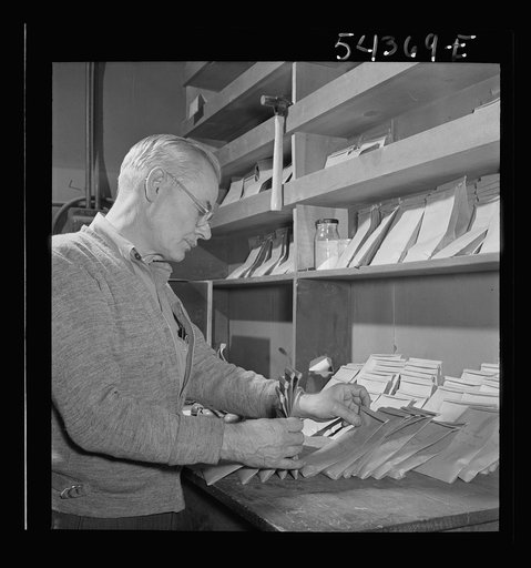 Kingman (vicinity), Arizona. A laboratory worker at a recovery plant near the Boriana mine selecting a sample of tungsten ore