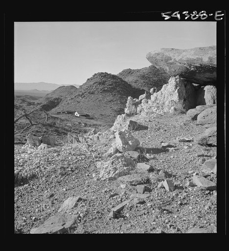 Untitled photo, possibly related to: Kingman (vicinity), Arizona. A view of a lonely ranch on the road to the Boriana mine, where tungsten ore is obtained, showing the type of desert coutry surrounding it