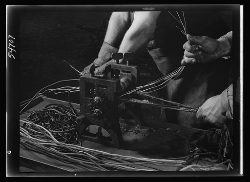 Boston and Maine railroad shops at Billerica, Massachusetts. Stripping wire clean of its rubber is a law now. Even these small lengths of wire which at one time were thrown out will be stripped of all its rubber insulation which will then be reclaimes