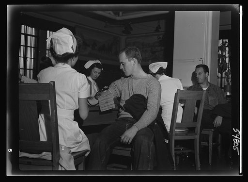 Nurses attached to the Red Cross mobile unit give a routine health checkup to San Quentin prisoners before they can give blood to the bank