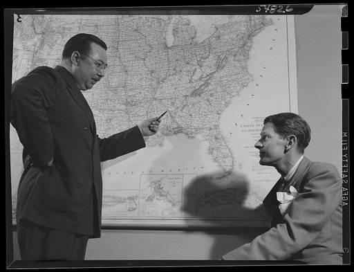 ODT (Office of Defense Transportation) system of port control. Henry F. McCarthy, director of the Division of Traffic Movement (right), discusses a prospective bottleneck development with assistant director Arch G. Warren, head of the Traffic Channels Section