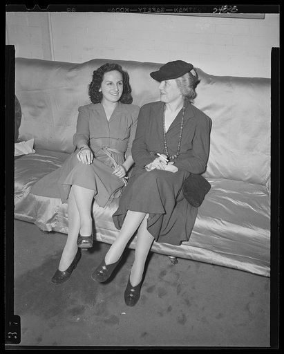 Washington, D.C. Miss Dorothea Erenreich, chairman of publicity for the Walsh Club for war workers, chatting with Mrs. James M. Landis, chairman of club centers for war workers, at a kitchen shower at the Walsh Club