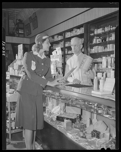 New York (and vicinity), New York. Miscellaneous photograph relating to the war effort. Woman volunteer checking and posting ceiling prices for the U.S. Office of Price Administration (OPA)