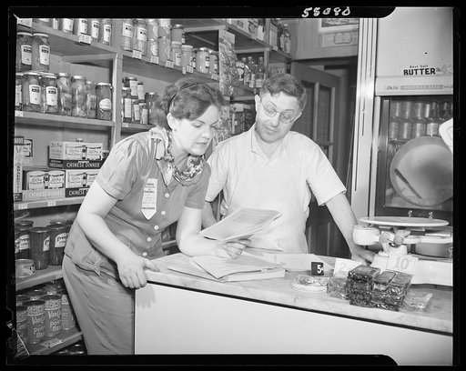 New York (and vicinity), New York. Miscellaneous photograph relating to the war effort. Woman volunteer checking and posting ceiling prices for the U.S. Office of Price Administration (OPA)
