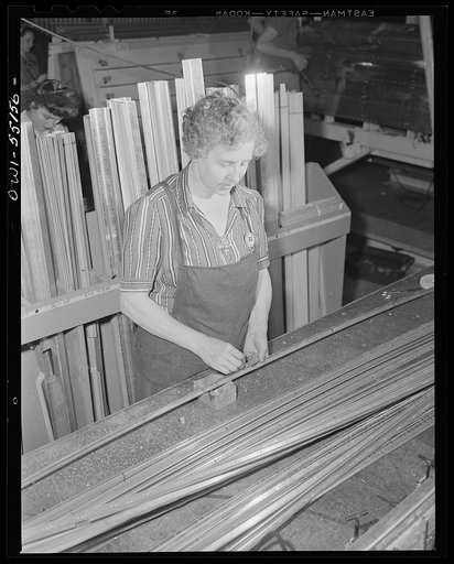 Elderly women as well as young women find work in the aircraft industry. This North American employee assembles stringers in the sheet metal sub-assembly department