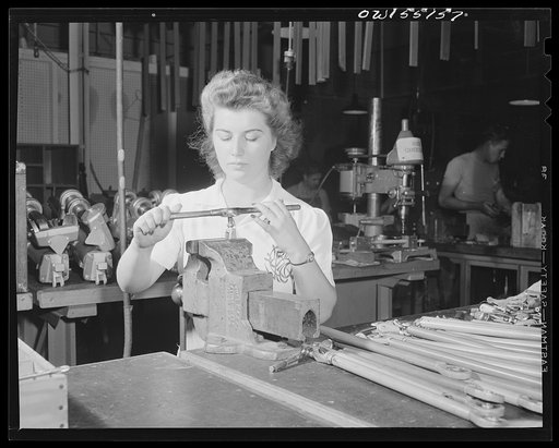 In the sub-assembly department, this woman employee assembles parts for North American B-25 bombers and P-51 Mustang fighters. Engine control rods
