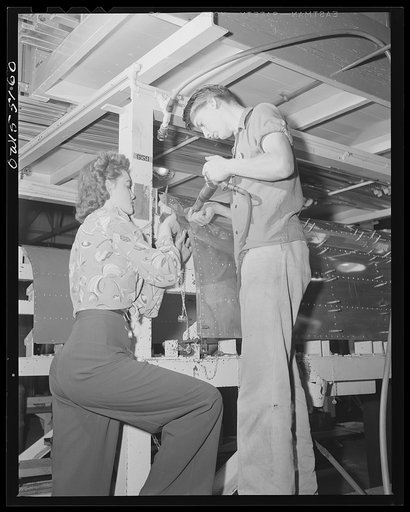 These two employees at North American Aviation work as a team while riveting a bomb bay door assembly for B-25