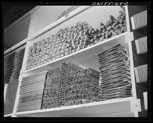 Sheet metal sub-assemblies for North American B-25 bombers and P-51 fighters are placed in huge stockrooms prior to release on assembly lines
