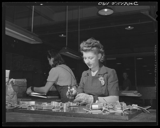 In the heat treat department, a girl stamps numbers on parts that have been passed by the inspector