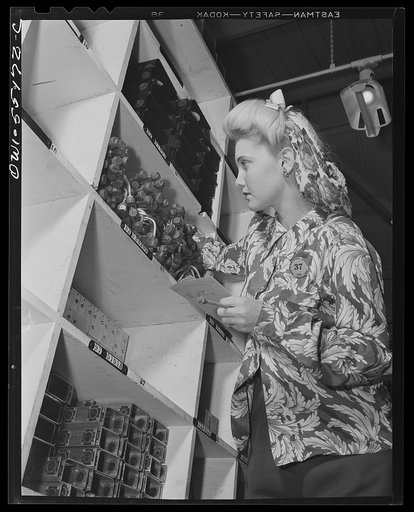A clerk in one of North American's stock rooms checks parts for a sub-assembly department