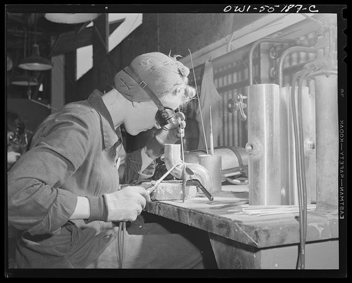 A woman welder at North American Aviation works on a sub-assembly for one of the huge tanks that go into the B-25 bombers