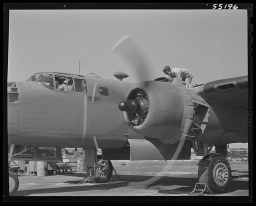 The motor on a North American B-25 bomber is adjusted before the initial flight