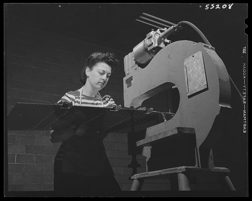 Kansas City, Kansas. A young girl at North American Aviation, Inc., operating a punch skin assembly
