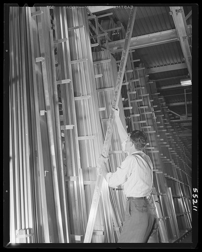 Kansas City, Kansas. A clerk in the stockroom of North American Aviation, Inc., stacking raw metal bars