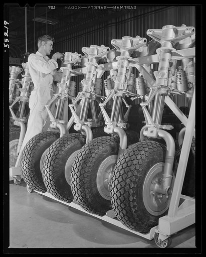 Kansas City, Kansas. A row of nose wheels for planes in a conveyor at an assembly plant of North American Aviation, Inc.