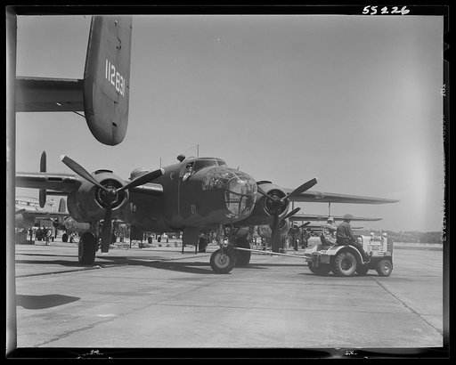 Untitled photo, possibly related to: Kansas City, Kansas. A B-25 bomber being hauled on the outdoor assembly line at North American Aviation, Inc.