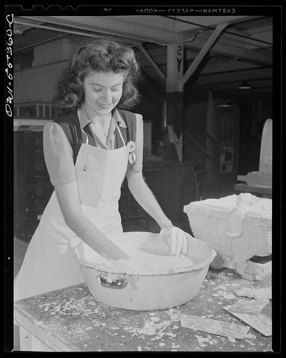 A young woman employee in North American Aviation's plaster forms department mixes plaster of paris for master plaster formers from which metal (kirksite) dies are formed