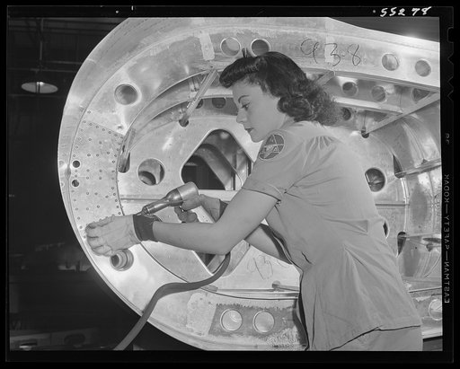 In North American's tank department, a woman employee rivets a rib. Tanks like these with high test gasoline enable United Nations bombers to fly faster and farther