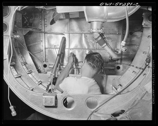 A North American employee assembles the landing gear mechanism inside the nacells of a B-25 bomber