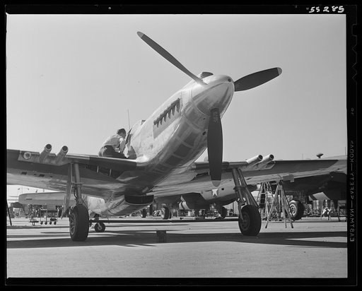 A North American P-51 fighter receives final inspection on the flight ramp before its first test flight