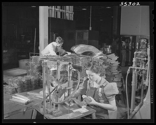 One of North American's women employees operates a pneumatic numbering machine in the sheet metal department. All items are given index numbers
