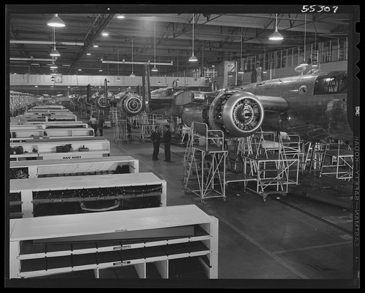On a powered conveyor line, North American B-25 bombers move down long final assembly lines