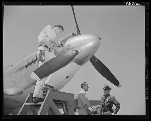 Final adjustments are made on the motor of a North American P-51 fighter before it is given its initial test flight. Plant protection officers are always on guard in all parts of the plant, particularly in this area
